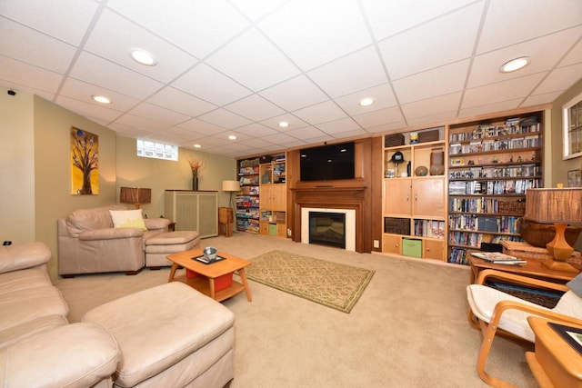 carpeted living room featuring recessed lighting, built in features, and a glass covered fireplace