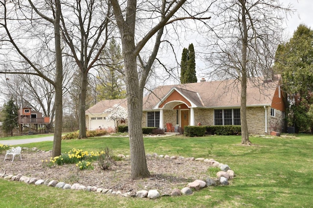 view of front of house featuring central air condition unit, a front yard, and stone siding