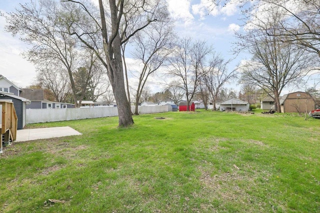 view of yard with fence and a storage shed