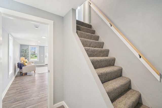 stairway with baseboards, recessed lighting, and wood finished floors