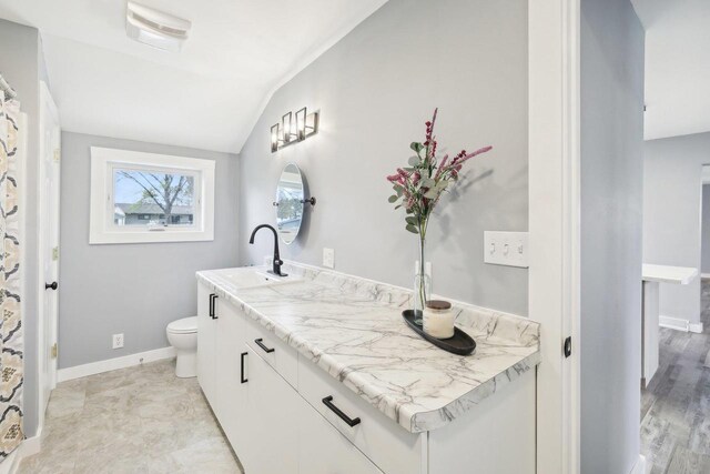 full bathroom featuring visible vents, vanity, baseboards, toilet, and lofted ceiling