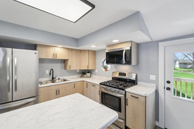 kitchen with recessed lighting, a sink, appliances with stainless steel finishes, and light brown cabinetry