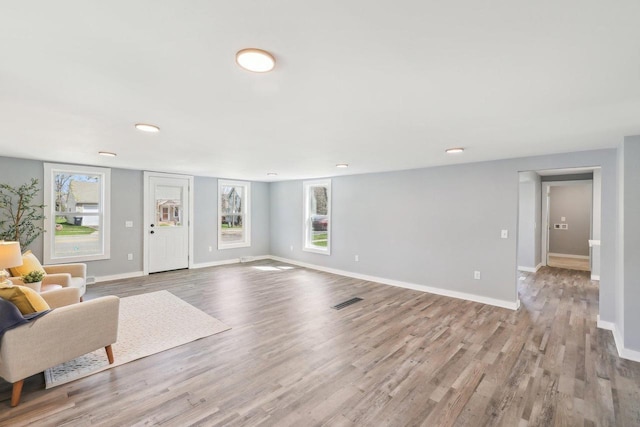 living room featuring baseboards, recessed lighting, wood finished floors, and visible vents