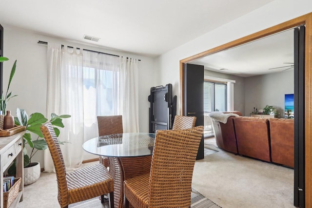 dining room featuring visible vents and light carpet