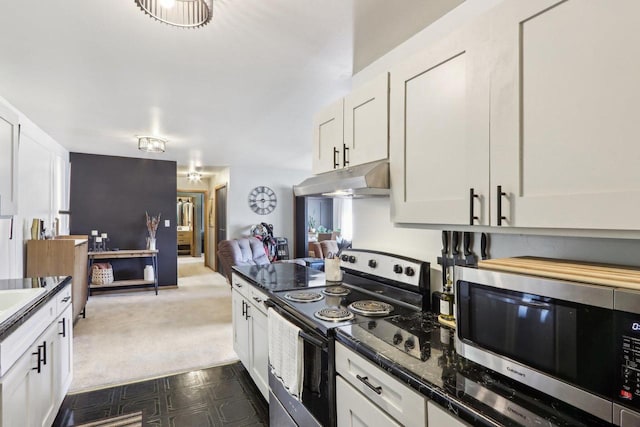 kitchen with stainless steel microwave, range with electric stovetop, under cabinet range hood, white cabinets, and open floor plan