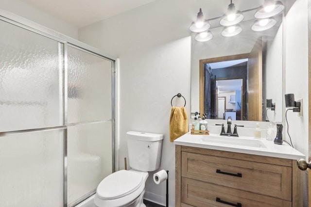 full bath featuring toilet, vanity, and a shower stall