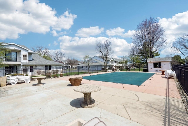 view of pool featuring fence, a residential view, a fenced in pool, and a patio area