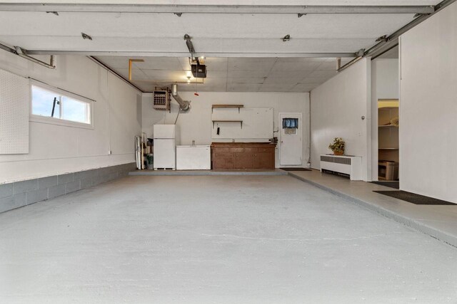 W2138 Melmar Dr, Markesan, WI 53946 - garage featuring a garage door opener, refrigerator, and freestanding refrigerator