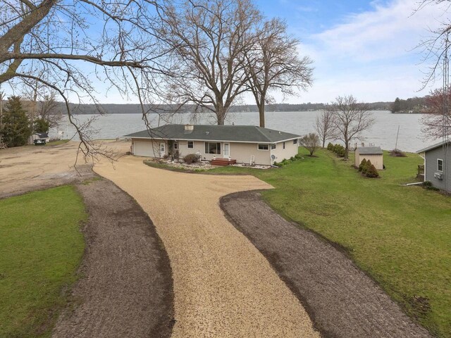 W2138 Melmar Dr, Markesan, WI 53946 - rear view of house with a yard, a water view, dirt driveway, a shed, and an attached garage