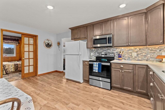 W2138 Melmar Dr, Markesan, WI 53946 - kitchen featuring light countertops, light wood finished floors, appliances with stainless steel finishes, and tasteful backsplash