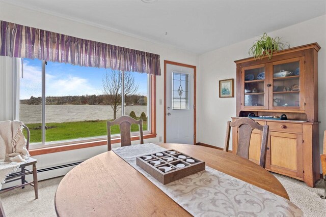 W2138 Melmar Dr, Markesan, WI 53946 - dining room featuring baseboard heating, light carpet, a water view, and plenty of natural light