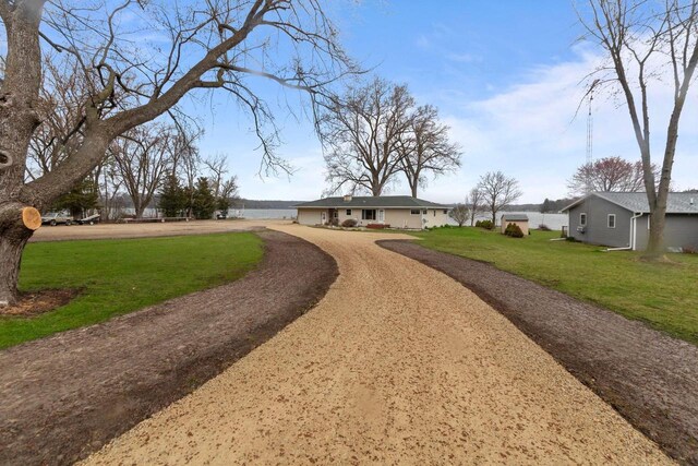 W2138 Melmar Dr, Markesan, WI 53946 - view of property's community featuring a lawn, driveway, and a garage