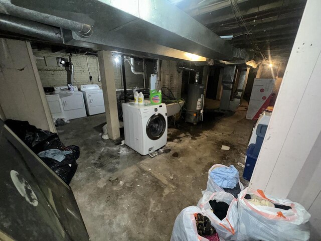unfinished basement with gas water heater and washer and clothes dryer