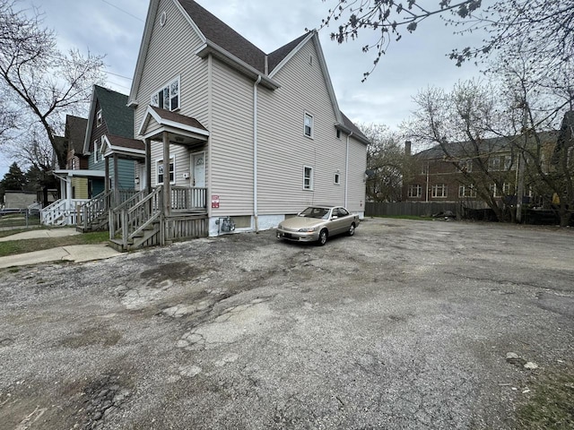 view of side of property featuring roof with shingles and a porch