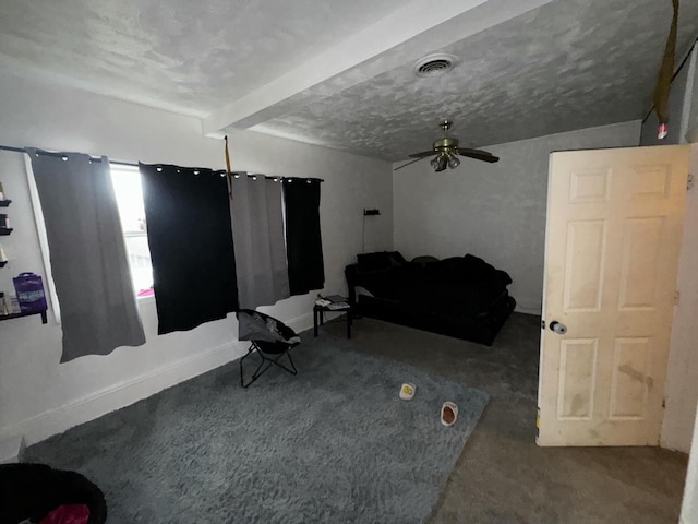 carpeted living room with beamed ceiling, ceiling fan, baseboards, visible vents, and a textured ceiling