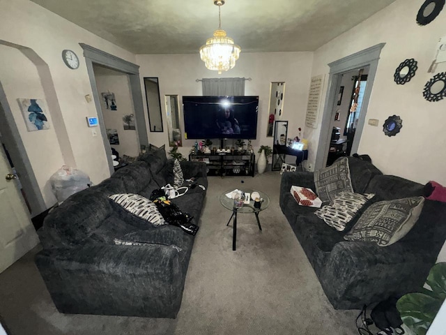carpeted living room featuring arched walkways and a chandelier