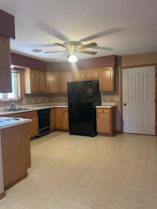 kitchen with light countertops, black appliances, a sink, a ceiling fan, and a textured ceiling