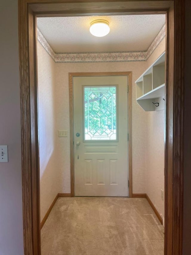 entryway featuring light colored carpet and baseboards
