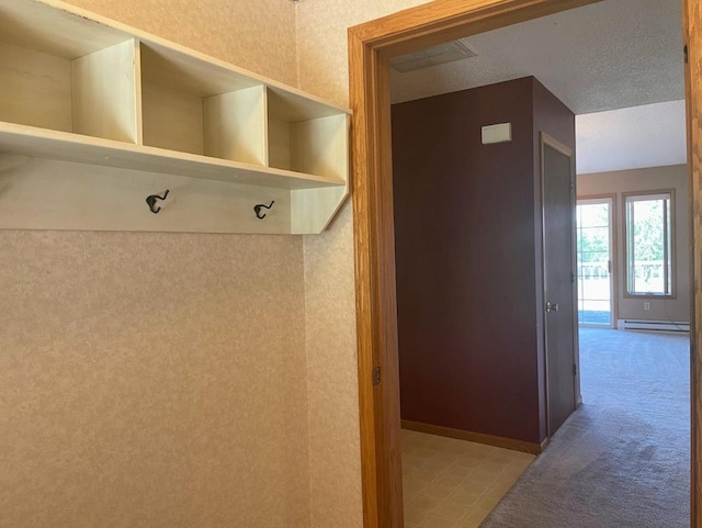 mudroom featuring a baseboard heating unit, carpet flooring, and baseboards