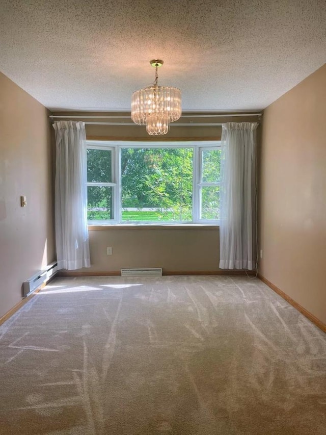 empty room featuring a chandelier, plenty of natural light, carpet, and a baseboard radiator