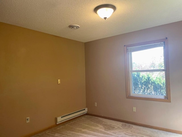carpeted empty room featuring a textured ceiling, visible vents, baseboard heating, and baseboards