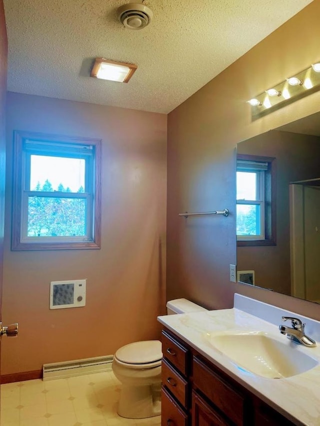 bathroom with vanity, tile patterned floors, toilet, a textured ceiling, and baseboard heating