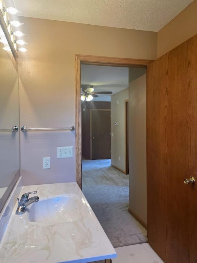 bathroom featuring a ceiling fan, a textured ceiling, and a sink