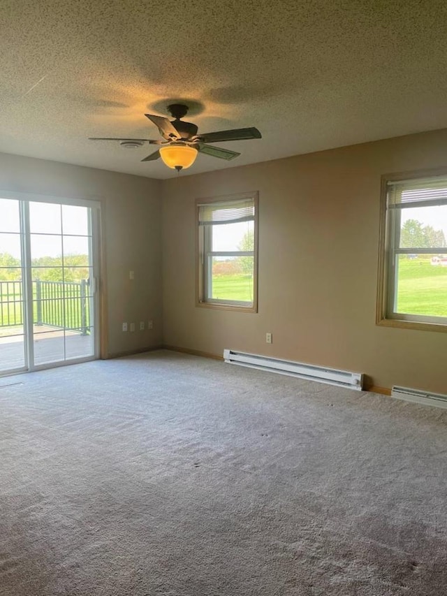 empty room with a baseboard radiator, a ceiling fan, a textured ceiling, and carpet floors