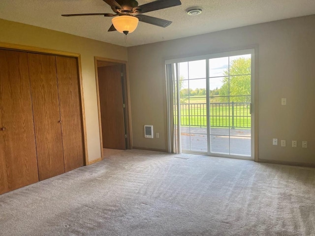 unfurnished bedroom featuring visible vents, access to exterior, carpet floors, and a textured ceiling