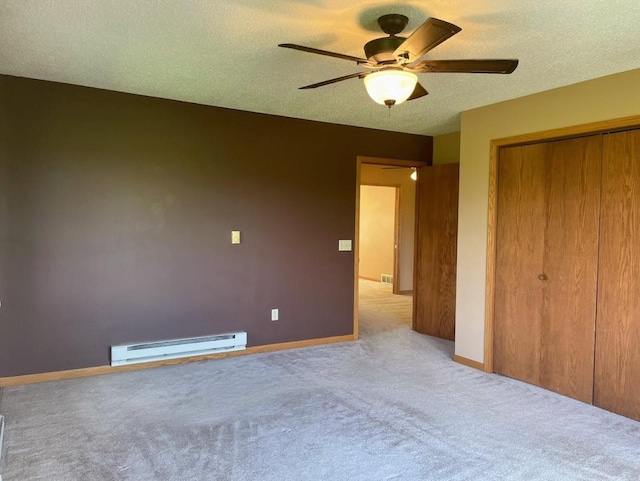 unfurnished bedroom featuring a closet, ceiling fan, baseboards, carpet floors, and a baseboard radiator
