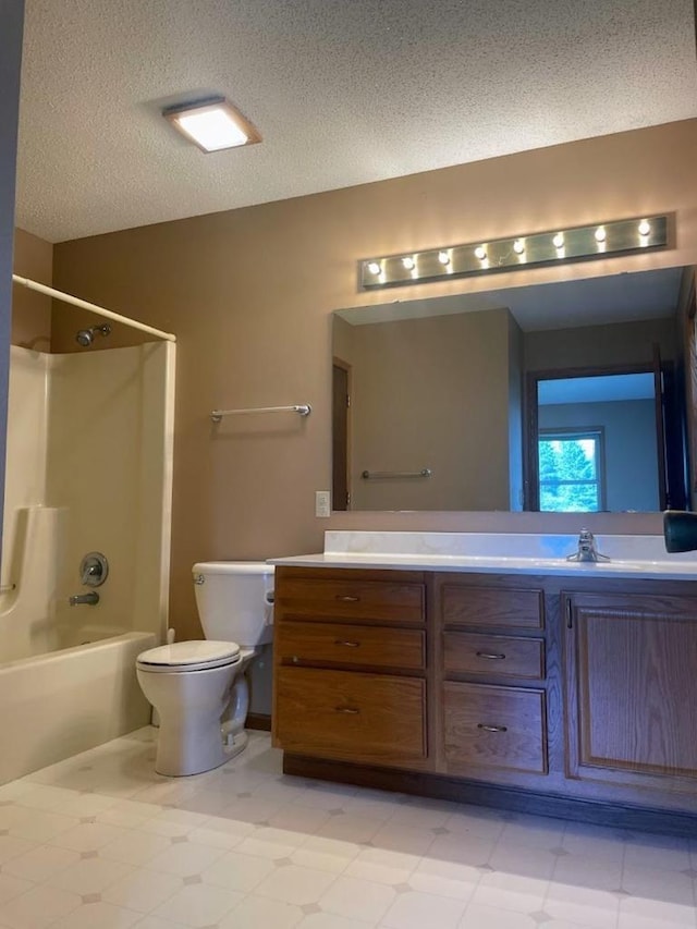 bathroom featuring vanity, tile patterned floors, toilet, bathtub / shower combination, and a textured ceiling