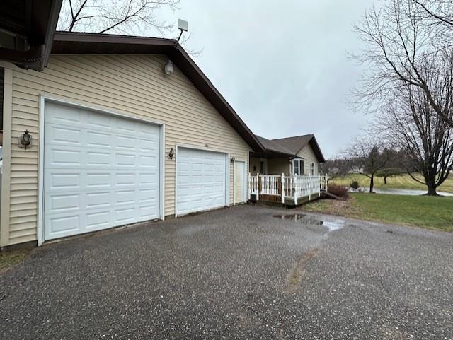 view of property exterior featuring driveway and an attached garage