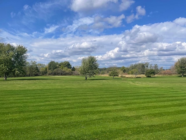 view of community with golf course view and a yard
