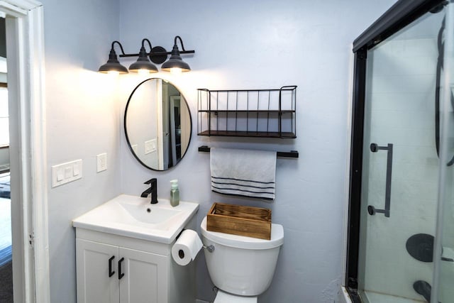 full bath with vanity, toilet, and a stall shower