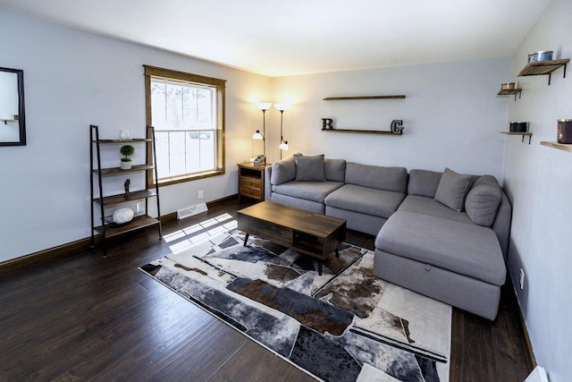 living room featuring wood finished floors, visible vents, and baseboards