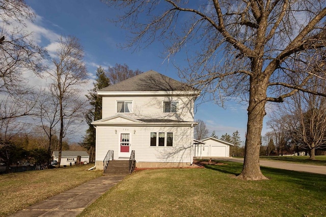 traditional-style home featuring an outdoor structure, a front yard, and a garage