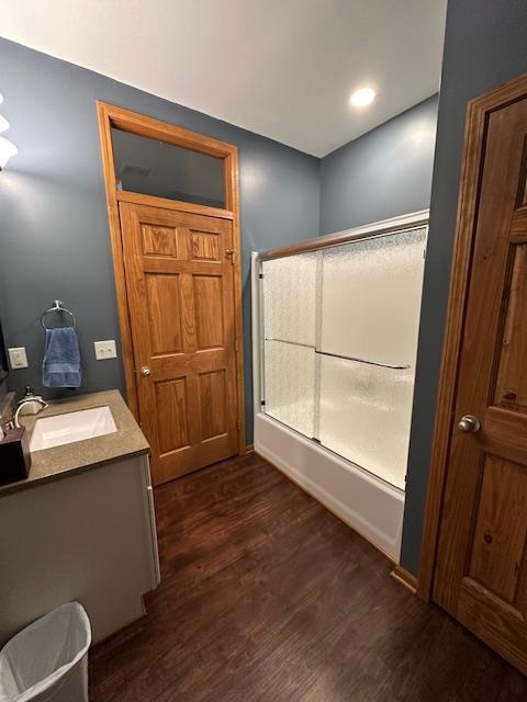 full bath featuring shower / bath combination with glass door, wood finished floors, and vanity