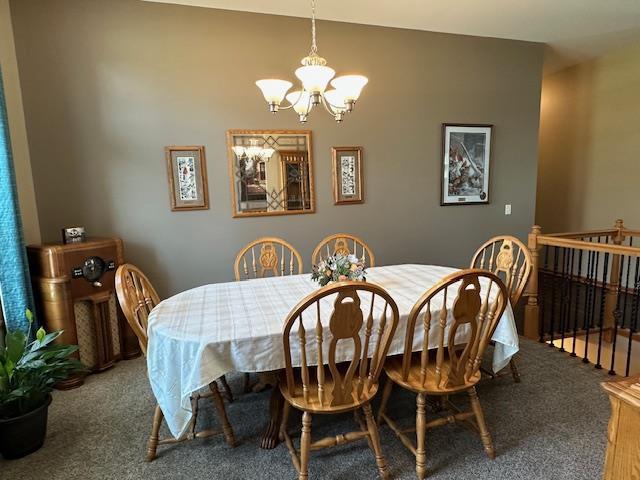 dining room with carpet floors and a notable chandelier