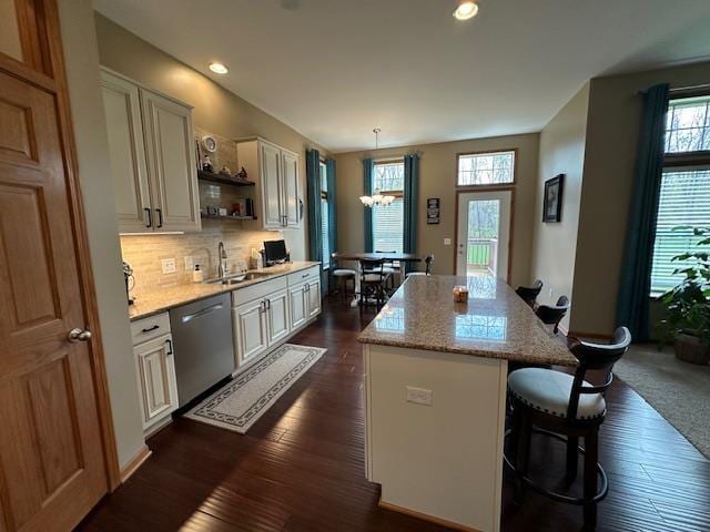 kitchen featuring a center island, stainless steel dishwasher, open shelves, dark wood finished floors, and a sink
