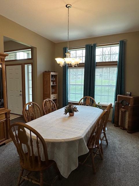dining room featuring carpet floors and an inviting chandelier
