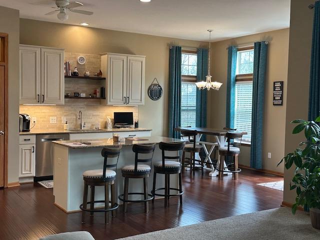 kitchen featuring a sink, white cabinets, stainless steel dishwasher, and open shelves