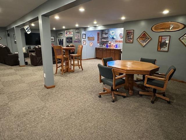dining room with a bar, recessed lighting, carpet, and baseboards