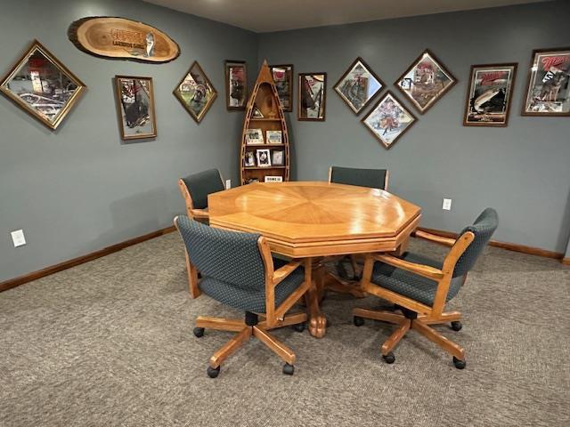 carpeted dining room with baseboards
