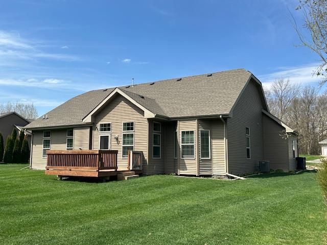 back of house with central air condition unit, a wooden deck, and a yard