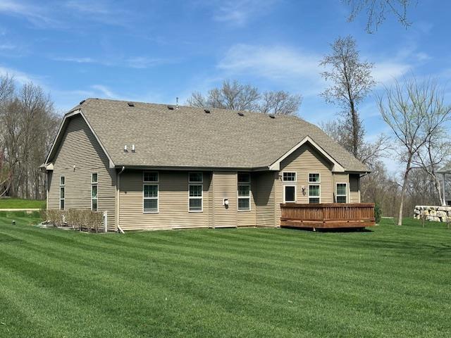 rear view of house featuring a lawn and a deck