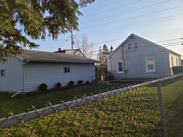 view of side of home featuring a lawn and a fenced backyard
