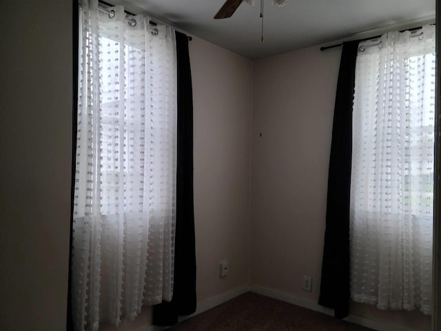 carpeted spare room with baseboards and ceiling fan