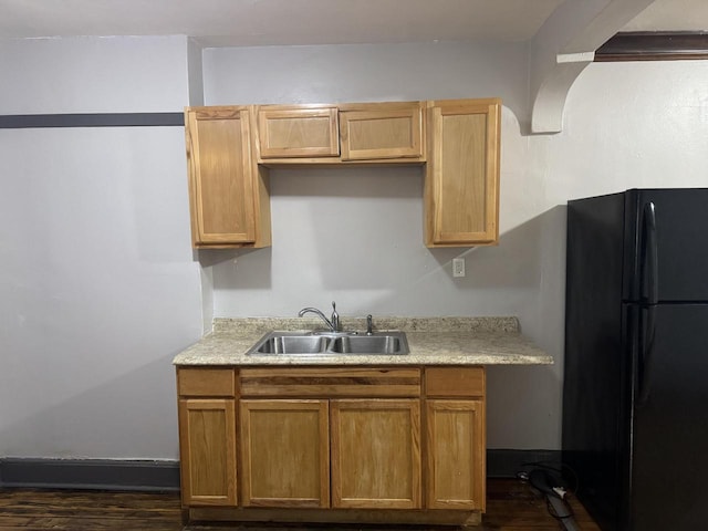 kitchen with dark wood finished floors, a sink, freestanding refrigerator, and light countertops