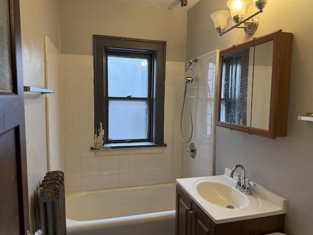 full bathroom featuring radiator heating unit, bathing tub / shower combination, and vanity