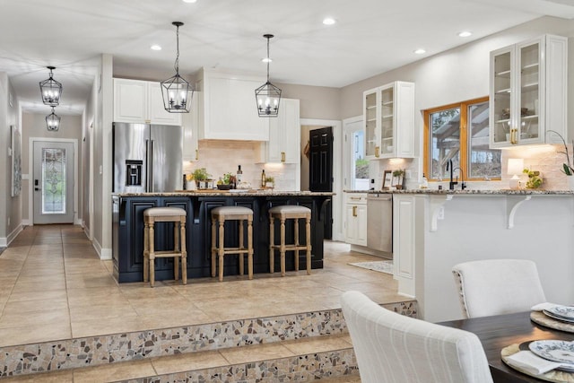 5400 N State Road 83, Hartland, WI 53029 - kitchen featuring light stone countertops, a kitchen breakfast bar, recessed lighting, tasteful backsplash, and stainless steel appliances
